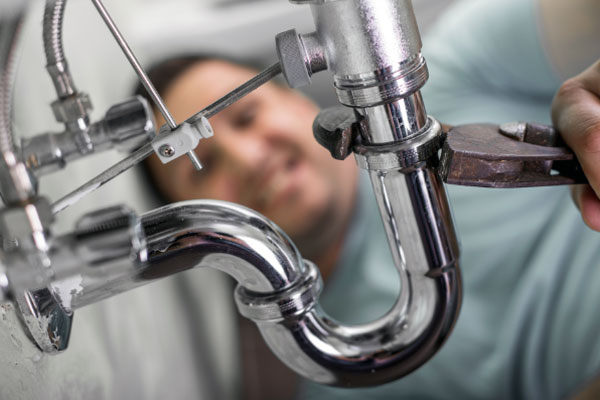 Plumber fixing leaking pipe